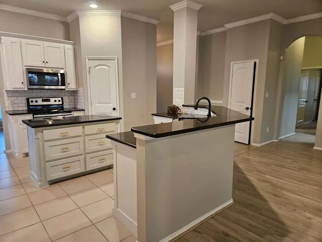 a kitchen with granite countertop a sink and a stove top oven