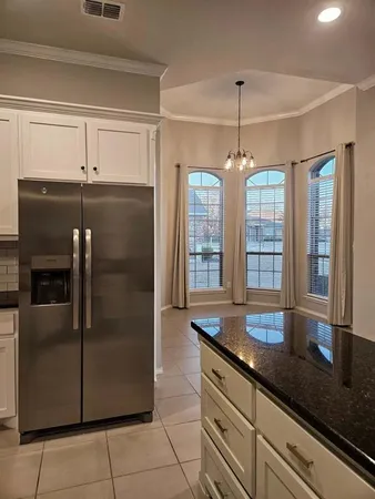 a kitchen with granite countertop a refrigerator a oven and a sink