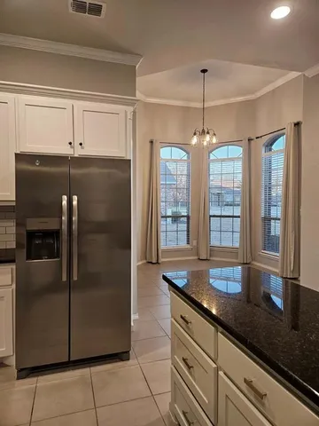 a kitchen with granite countertop a refrigerator a oven and a sink
