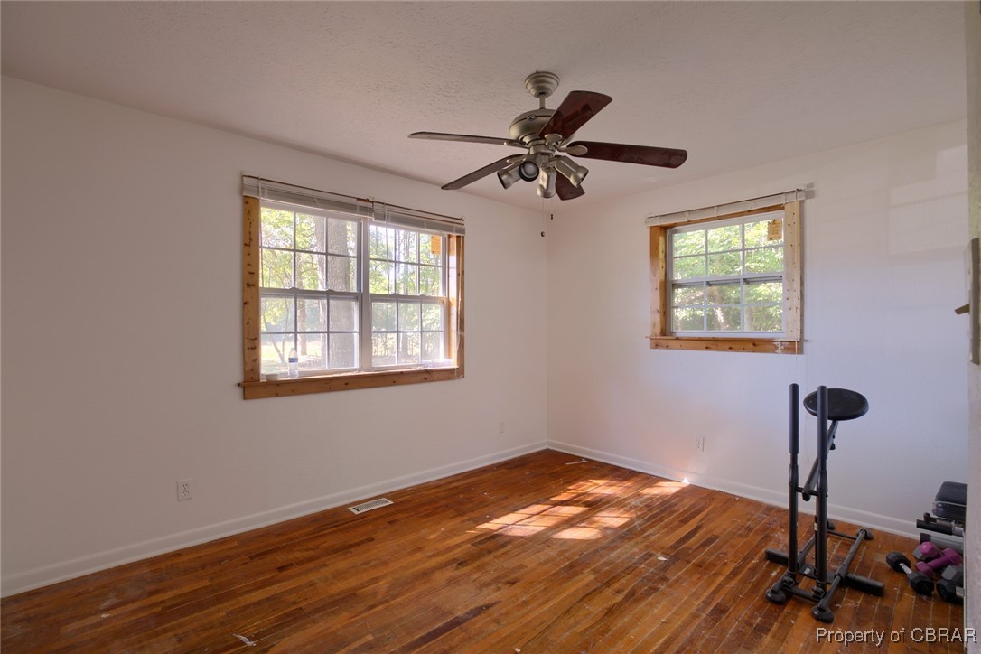 6153 Fletcher Road Gloucester, VA 23061 - Photo 11 of 16 Empty room with dark hardwood / wood-style floors, plenty of natural light, and ceiling fan