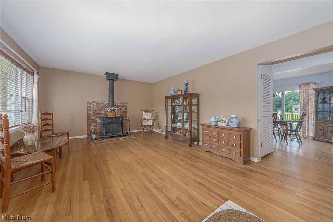 3331 Boyne Road Barberton, OH 44203 - Photo 3 of 22 Lovely living room with hardwood floors, a charming wood-burning stove, and plenty of natural sunlight beaming through. Windows has an easy cleaning feature that allows the window to tilt out.