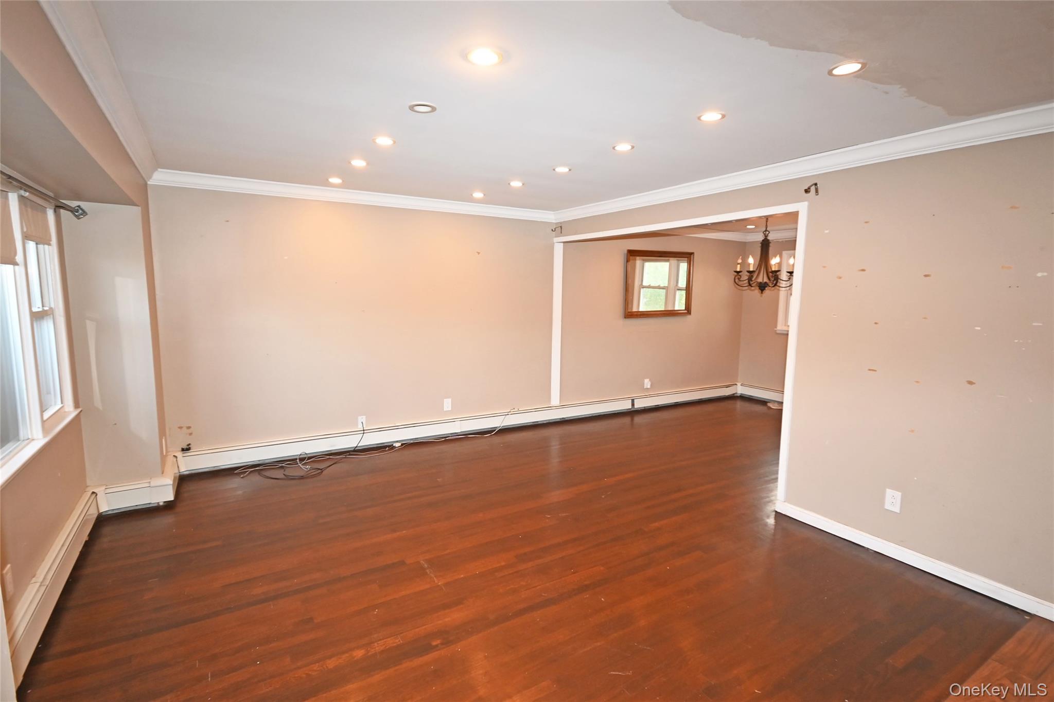 89 Osborne Road West Hempstead, NY 11552 - Photo 22 of 50 Spare room featuring ornamental molding, recessed lighting, dark wood-type flooring, a chandelier, and baseboard heating