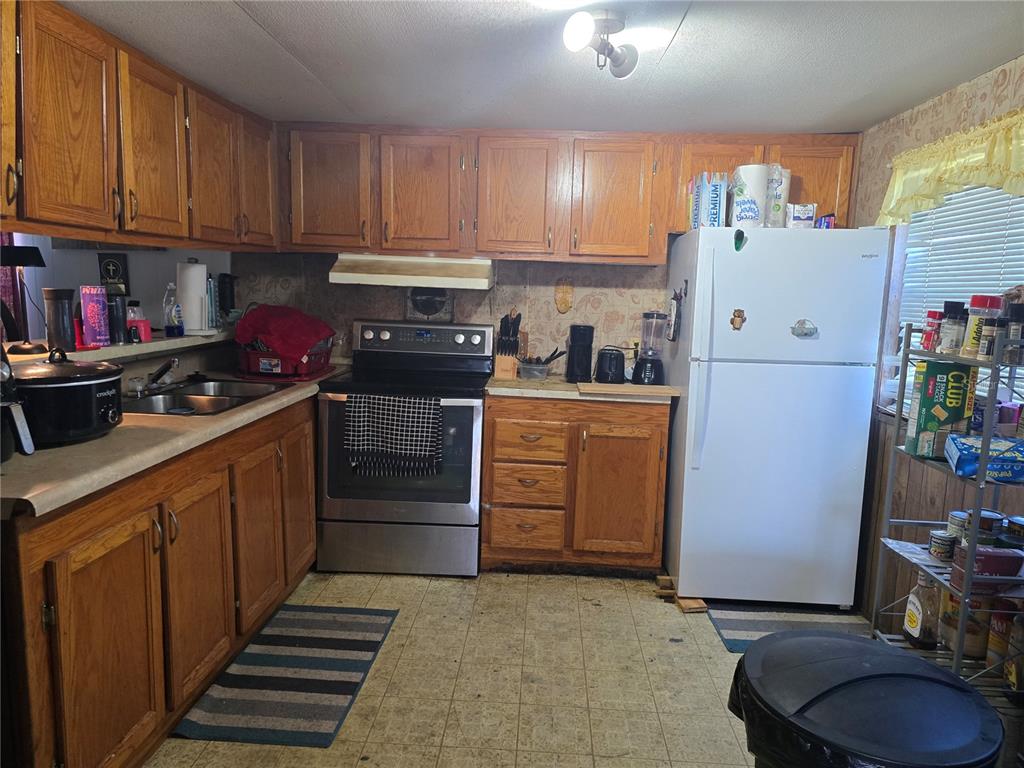 513 Smith Road Polk City, FL 33868 - Photo 6 of 33 a kitchen with a white stove top oven and cabinets