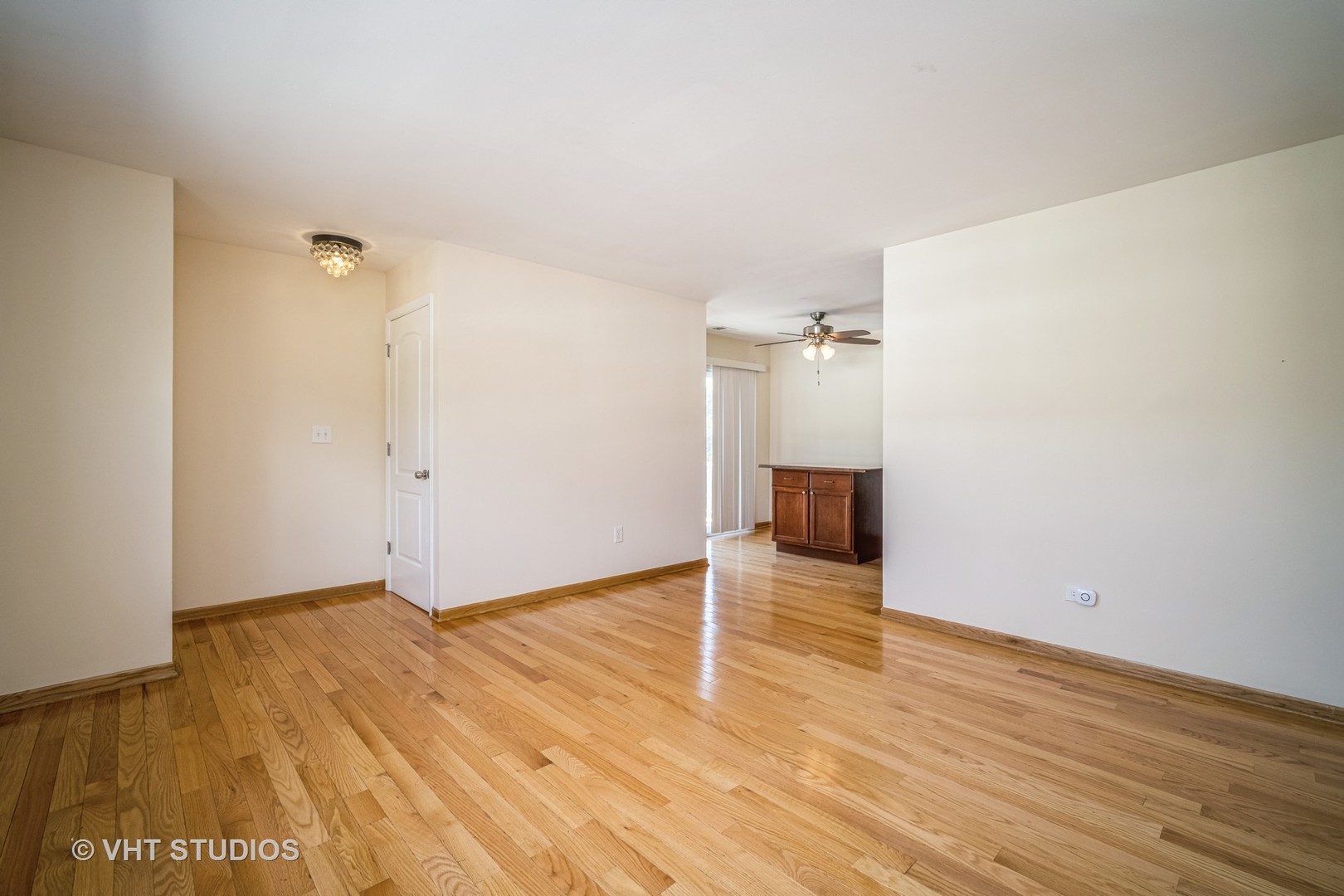 684 Cleo Court, Unit 684 Wheeling, IL 60090 - Photo 3 of 13 an empty room with wooden floor and fireplace