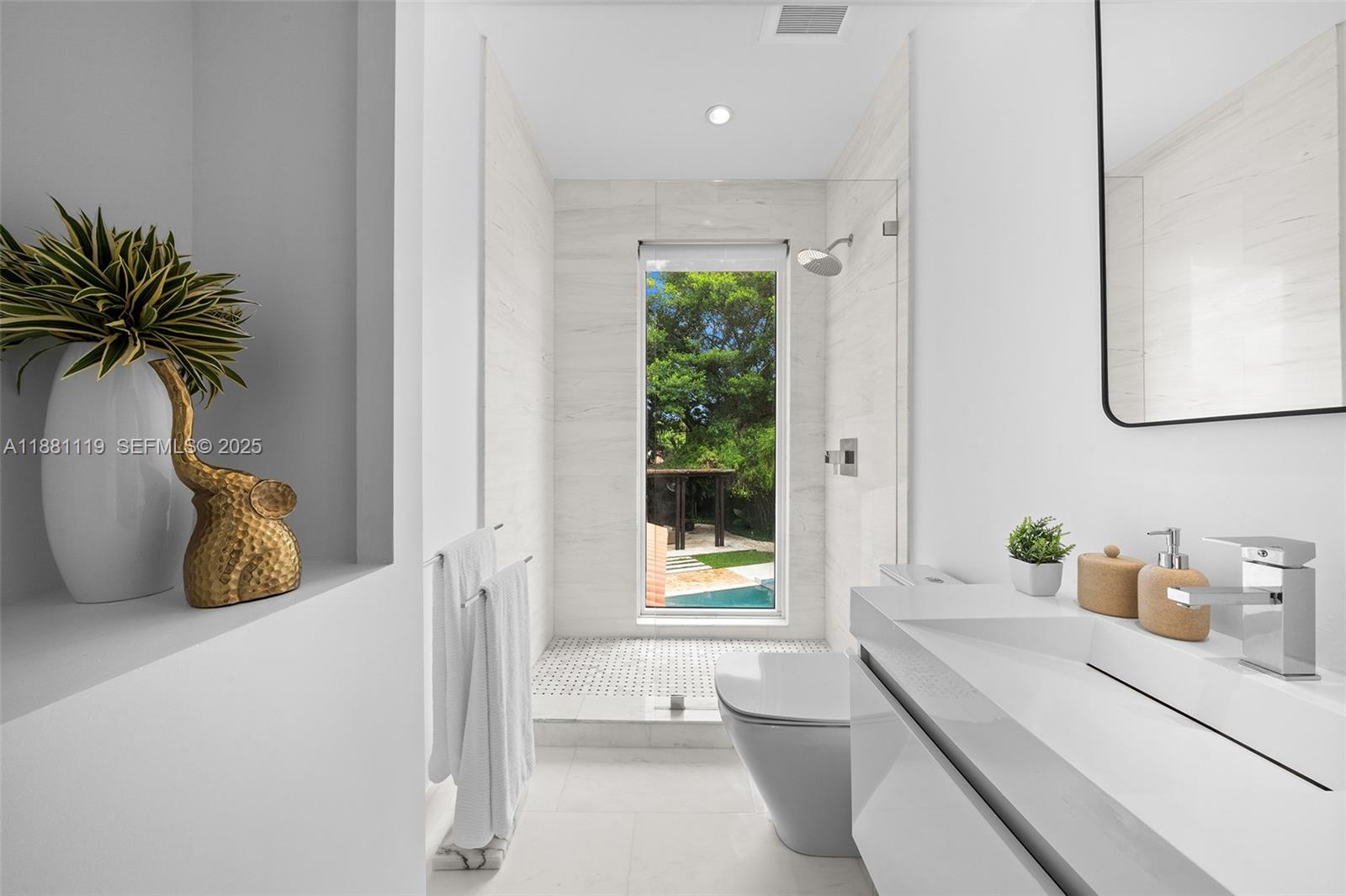 575 Bay Point Road Miami, FL 33137 - Photo 15 of 87 a bathroom with a sink a mirror and a window