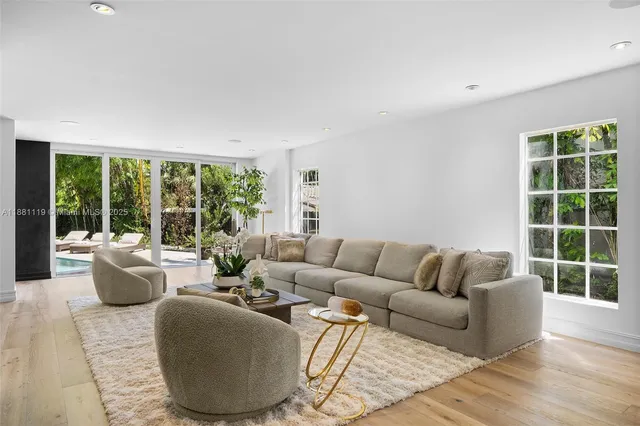 a kitchen with kitchen island granite countertop a table chairs stove and wooden floor