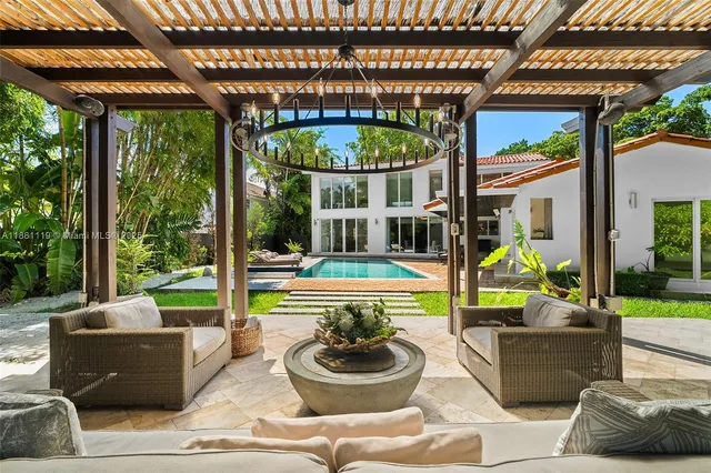 a living room with patio furniture and a large window