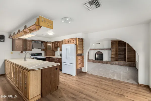 a kitchen with refrigerator cabinets and a wooden floor