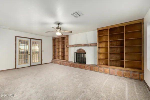a view of an empty room with a fireplace and a window