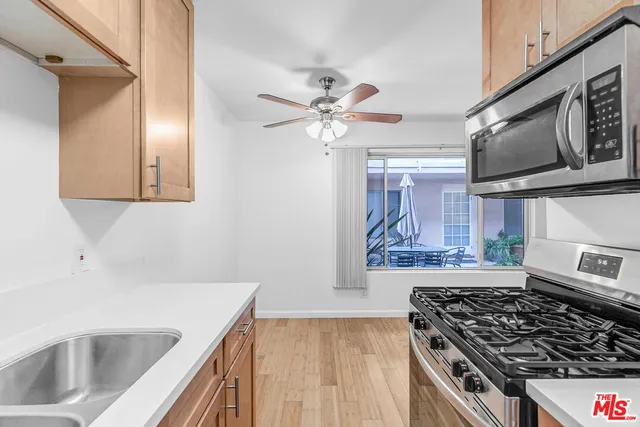 a kitchen with stainless steel appliances a stove a sink and a microwave