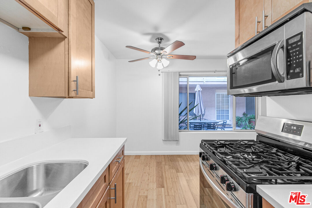 a kitchen with stainless steel appliances a stove a sink and a microwave