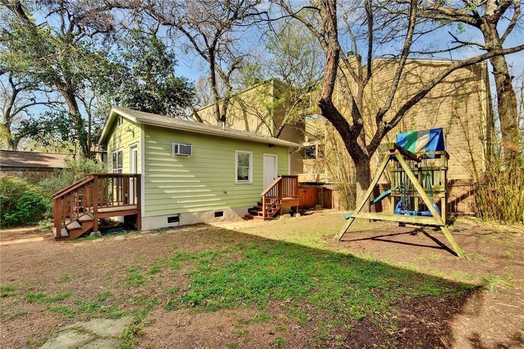 4412 Barrow Avenue, Unit A Austin, TX 78751 - Photo 26 of 28 Rear view of property featuring crawl space, a playground, an AC wall unit, and a yard