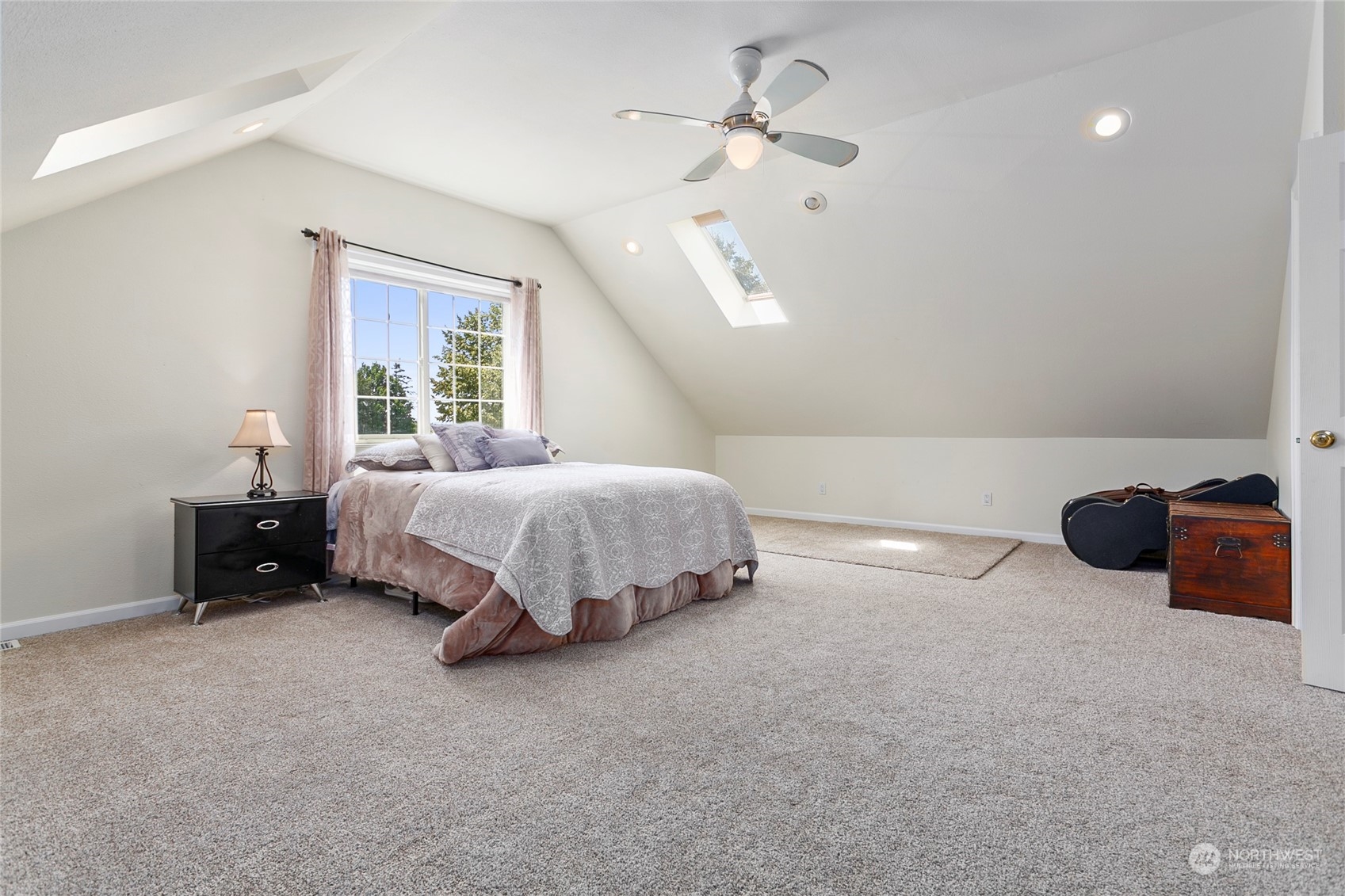 7730 Goodwin Road Everson, WA 98247 - Photo 29 of 39 a spacious bedroom with a bed and a chandelier