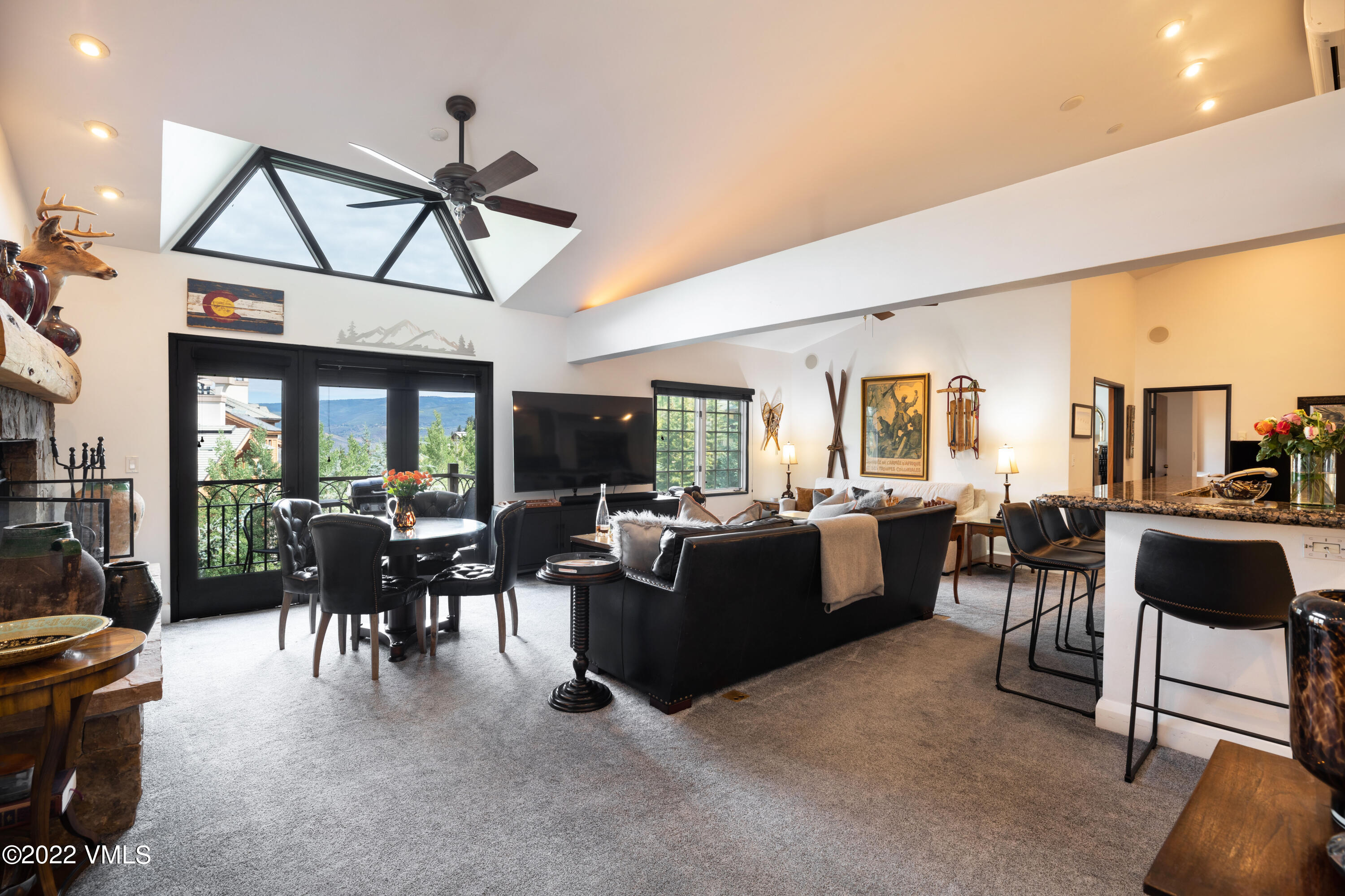 a living room with furniture a dining table and a floor to ceiling window