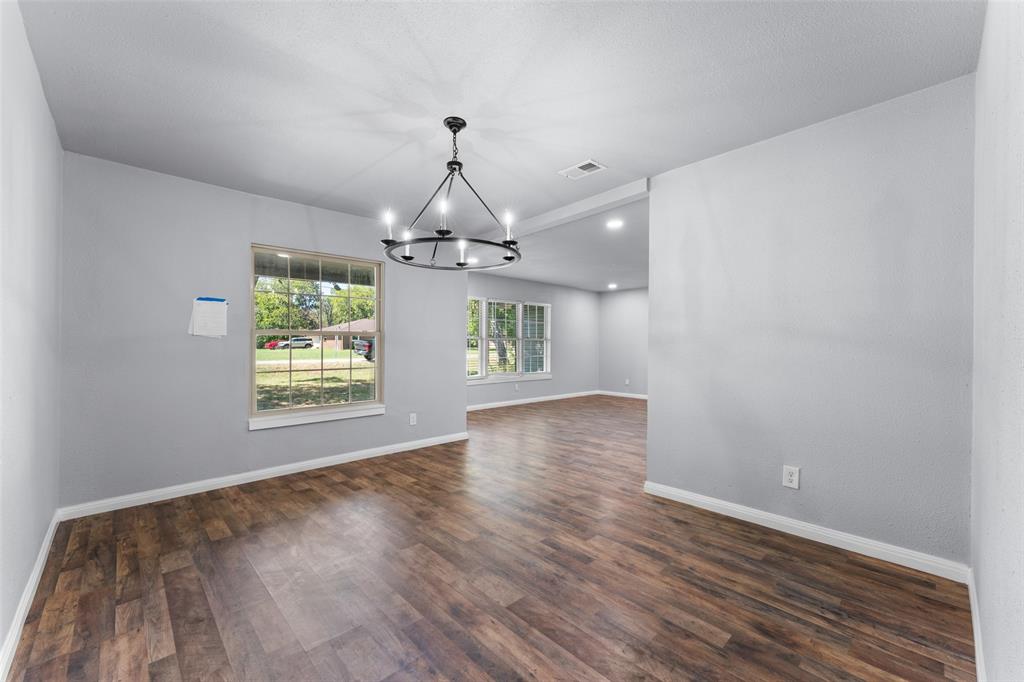 612 East 8th Street Kemp, TX 75143 - Photo 9 of 25 Spacious room featuring wood-finish flooring, a contemporary chandelier, recessed lighting, and multiple windows