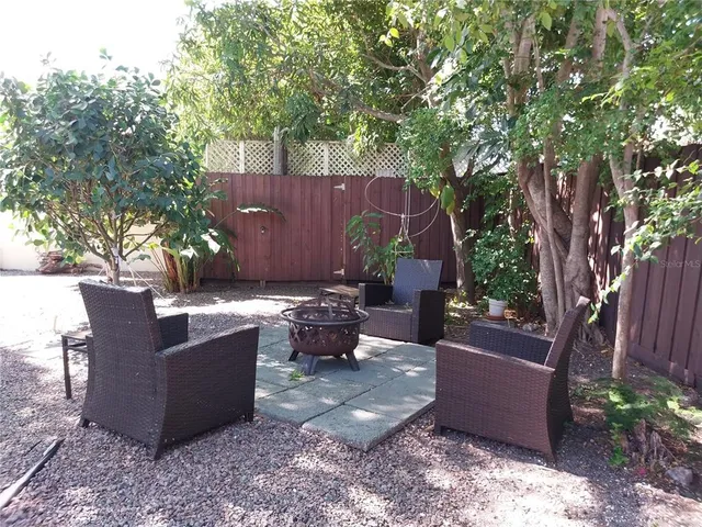 a view of a backyard with a tub and couches under an umbrella