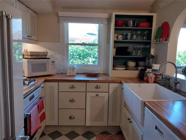 a kitchen with stainless steel appliances a sink cabinets and a window