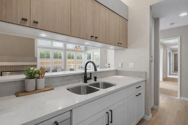 a kitchen with white cabinets and appliances