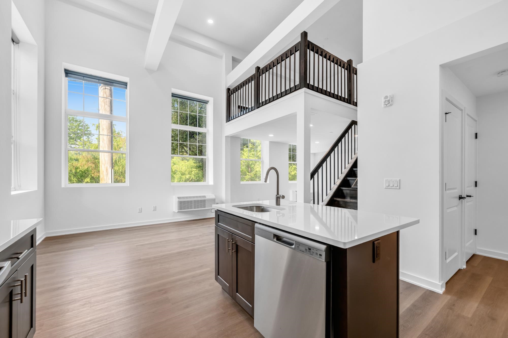a view of a hallway with wooden floor and staircase