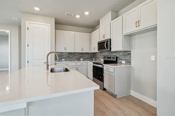 a kitchen with cabinets appliances a sink and a counter
