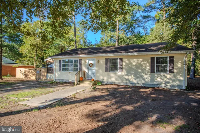 a front view of a house with a yard tree and outdoor seating