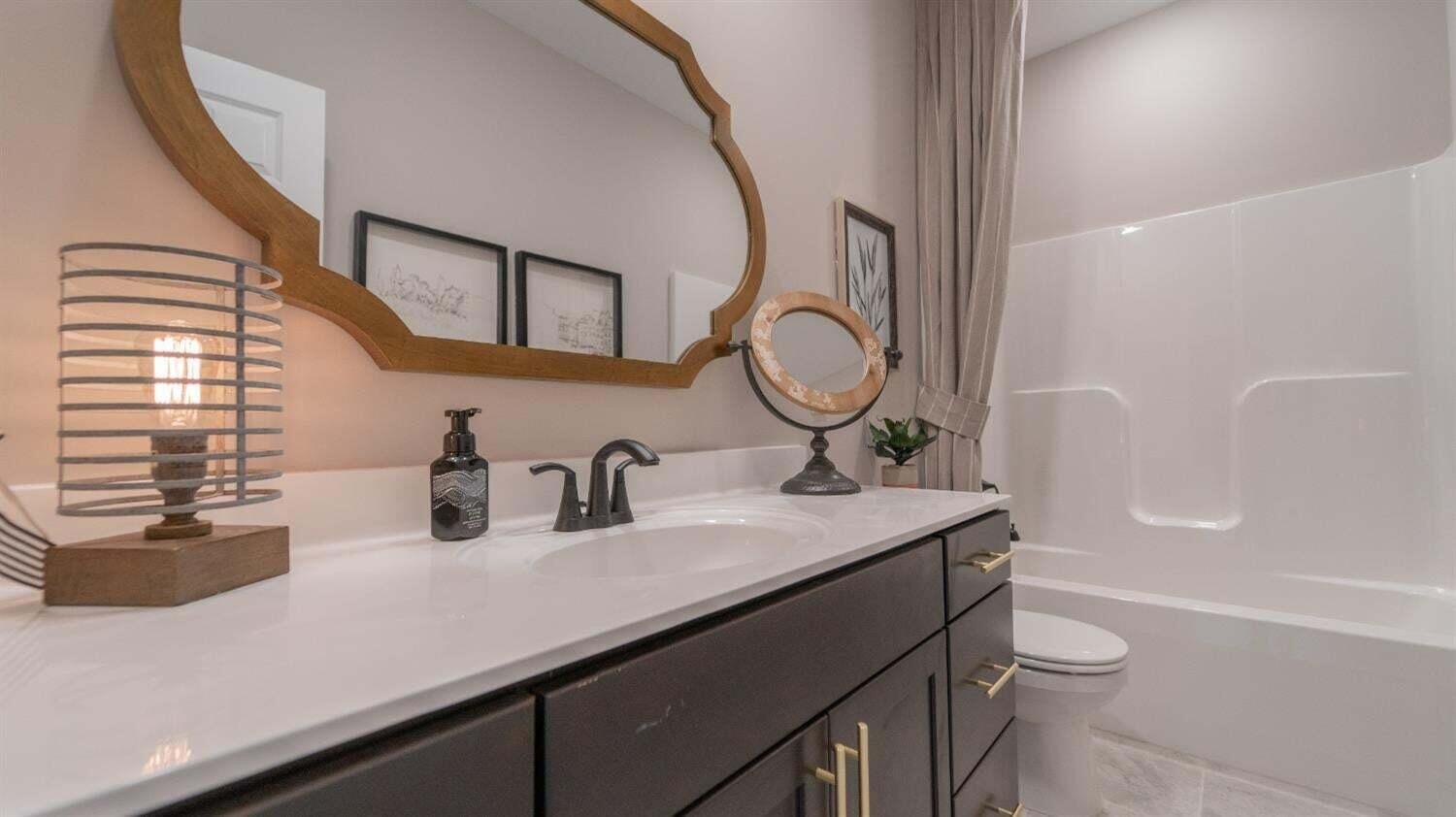 3098 Fawn Lane Portage, IN 46368 - Photo 12 of 22 a bathroom with a granite countertop sink toilet a mirror and bathtub