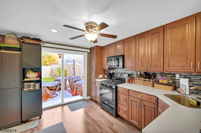 a kitchen with a refrigerator a stove a sink dishwasher with a dining table and chairs with wooden floor