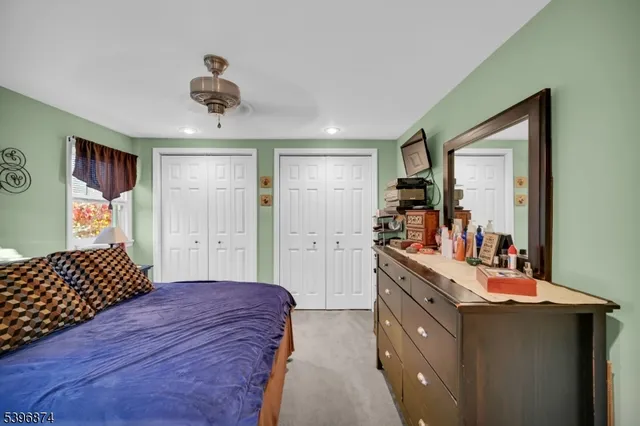 a bedroom with a bed and dresser with mirror