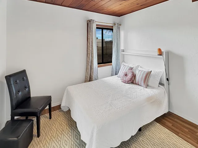 a bedroom with a bed a chair and a window