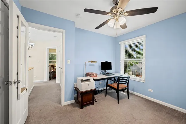 a view of a workspace with furniture and a window