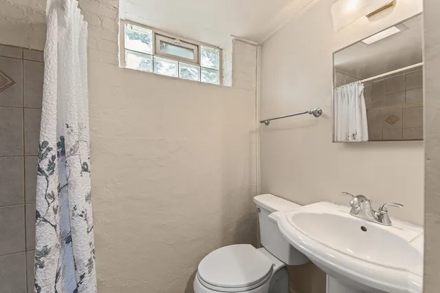 a bathroom with a sink toilet and mirror