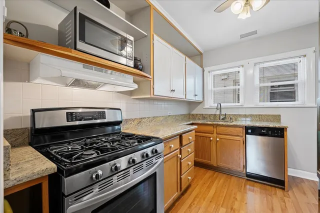 a kitchen with stainless steel appliances granite countertop a stove and a sink