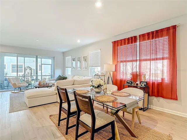 a kitchen with stainless steel appliances granite countertop white cabinets a sink a stove a refrigerator and dishwasher with wooden floor