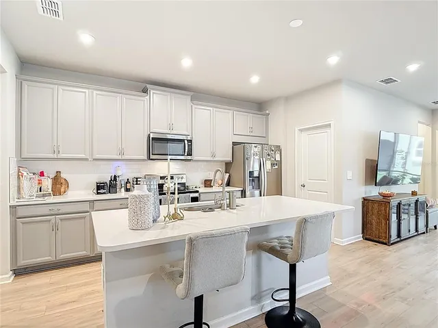 a kitchen with stainless steel appliances granite countertop a refrigerator sink and stove