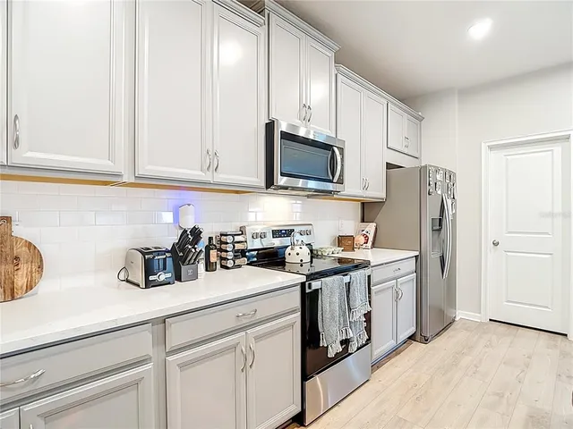 a kitchen with stainless steel appliances kitchen island a sink a stove a refrigerator and cabinets
