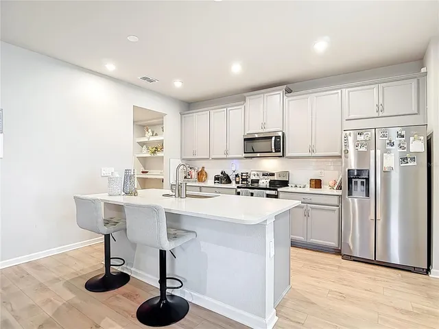 a living room with furniture kitchen view and a flat screen tv