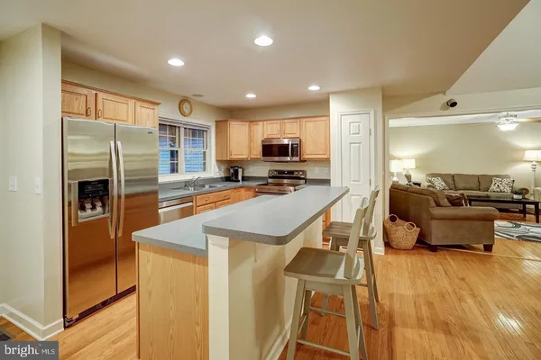 a kitchen with stainless steel appliances granite countertop a refrigerator a stove and a sink