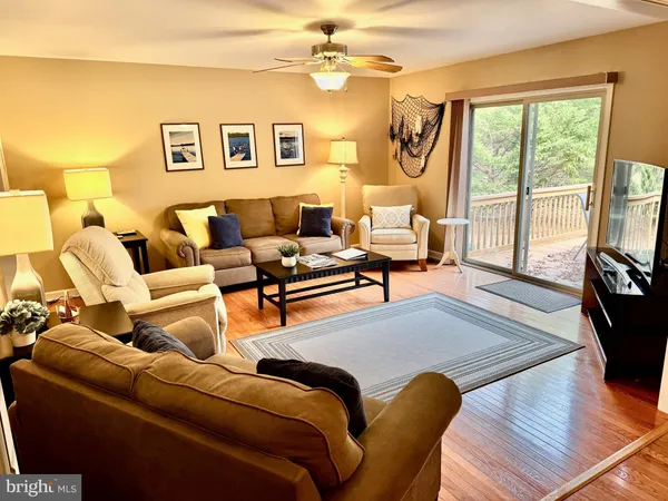 a living room with furniture large window and flat screen tv