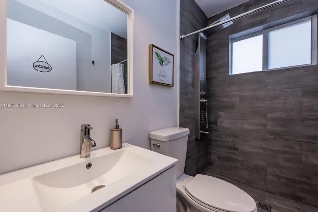 a bathroom with a toilet sink and mirror