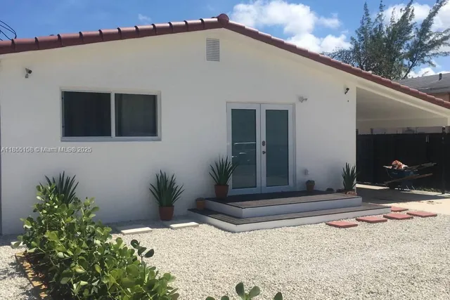 a backyard of a house with potted plants and trees