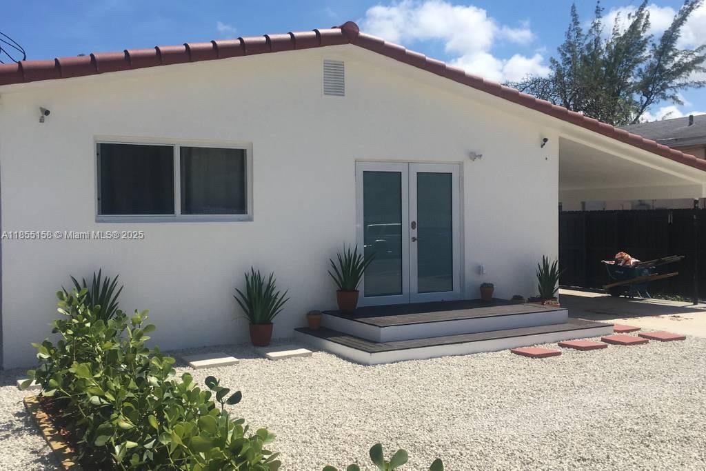 350 Northwest 50th Street Miami, FL 33127 - Photo 2 of 27 a backyard of a house with potted plants and trees