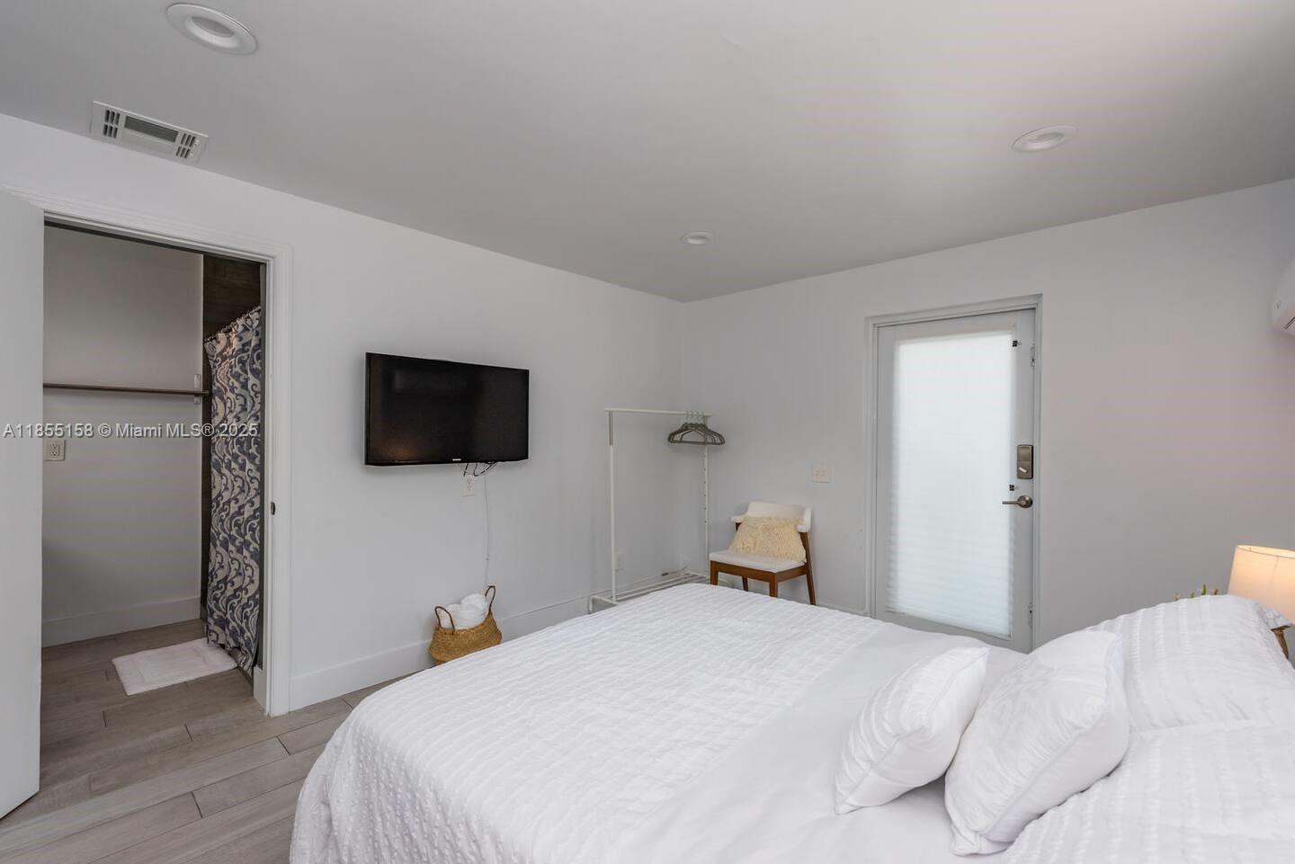 350 Northwest 50th Street Miami, FL 33127 - Photo 24 of 27 a bedroom with a bed and a flat screen tv