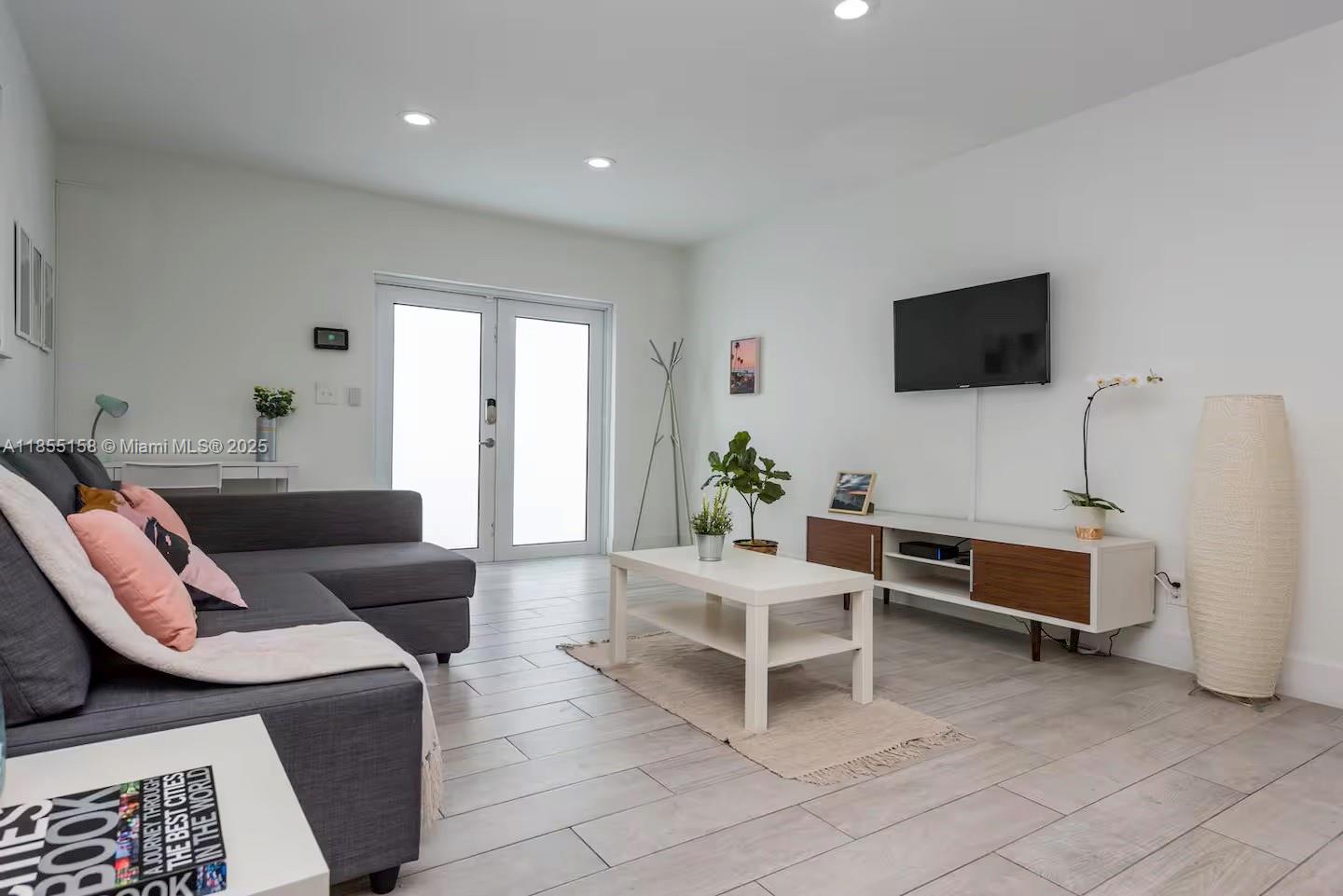 350 Northwest 50th Street Miami, FL 33127 - Photo 4 of 27 a living room with furniture and a flat screen tv