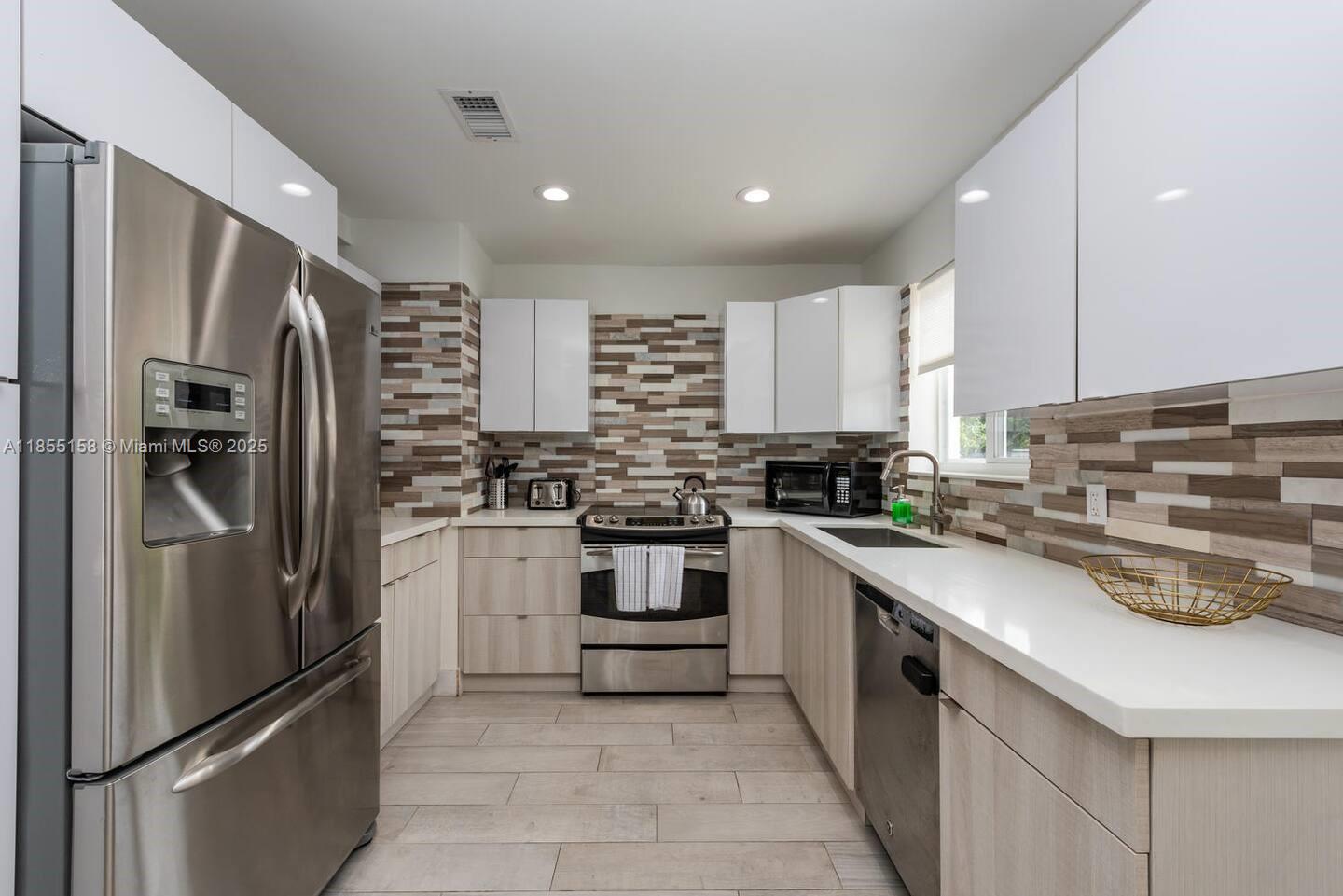 350 Northwest 50th Street Miami, FL 33127 - Photo 9 of 27 a kitchen with stainless steel appliances a refrigerator sink and microwave