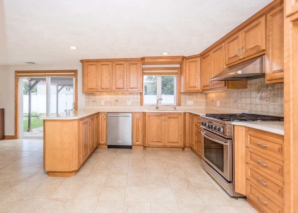 129 Beal Road Waltham, MA 02453 - Photo 11 of 31 a kitchen with stainless steel appliances granite countertop a stove a sink and a refrigerator