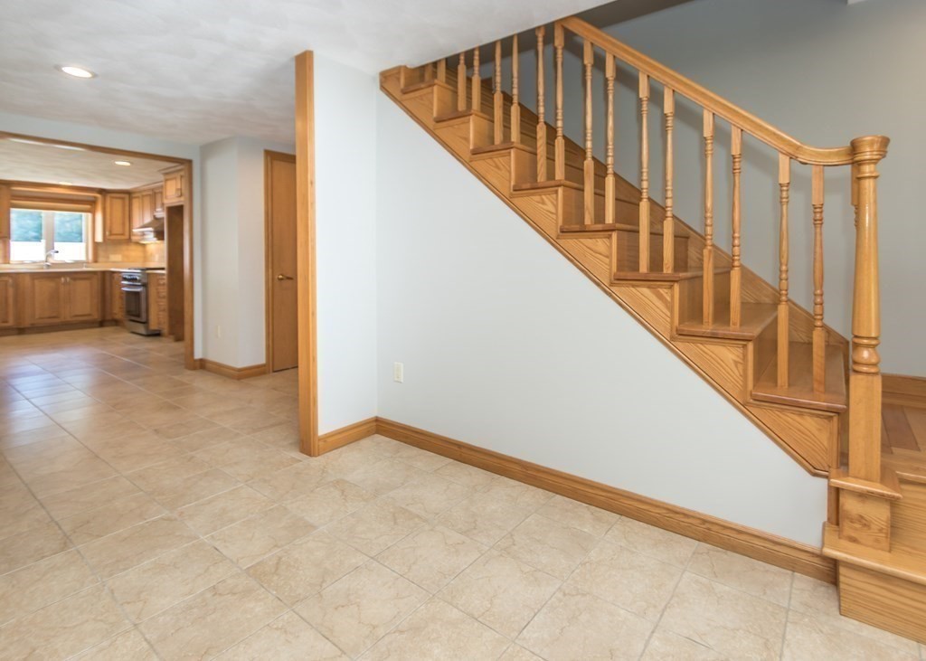 129 Beal Road Waltham, MA 02453 - Photo 14 of 31 a view of an entryway with wooden floor leading to a furnished livingroom and stairs