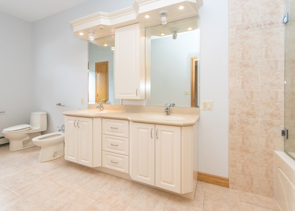 129 Beal Road Waltham, MA 02453 - Photo 20 of 31 a bathroom with a double vanity sink a toilet and a mirror