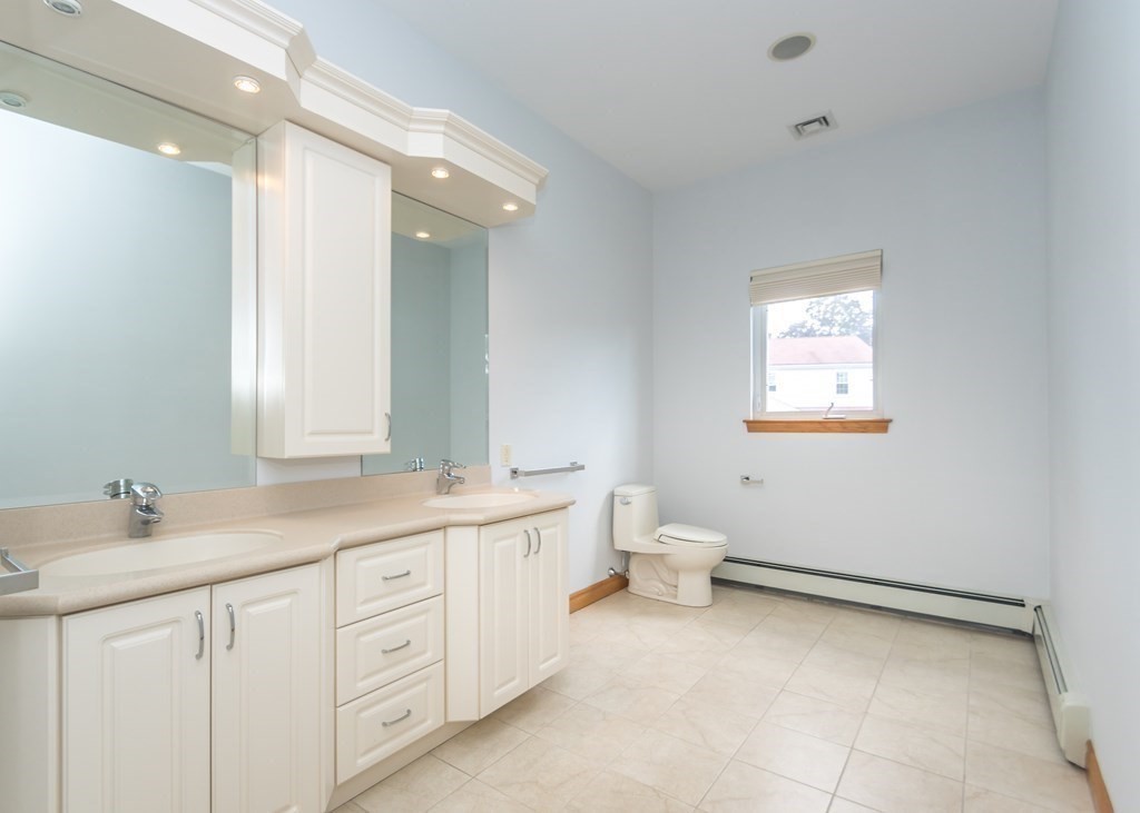 129 Beal Road Waltham, MA 02453 - Photo 21 of 31 a spacious bathroom with a double vanity sink a mirror and a toilet