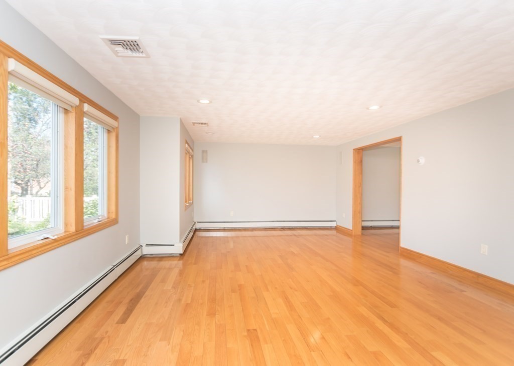 129 Beal Road Waltham, MA 02453 - Photo 5 of 31 a view of an empty room with a window and wooden floor