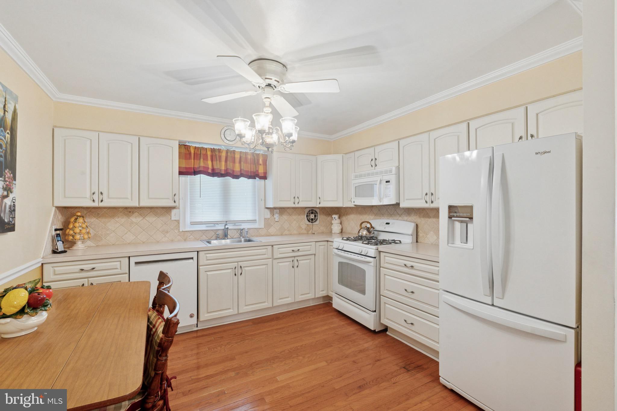 7026 Crease Lane Philadelphia, PA 19128 - Photo 14 of 41 a kitchen with stainless steel appliances granite countertop a refrigerator a sink dishwasher a stove and white countertops with wooden floor